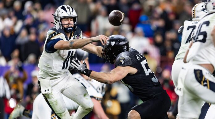 Navy Triumphs Over Army in Decisive 2024 Showdown Navy's BLAKE HORVATH (11) makes a pass before being tackled during the game between Army and Navy.